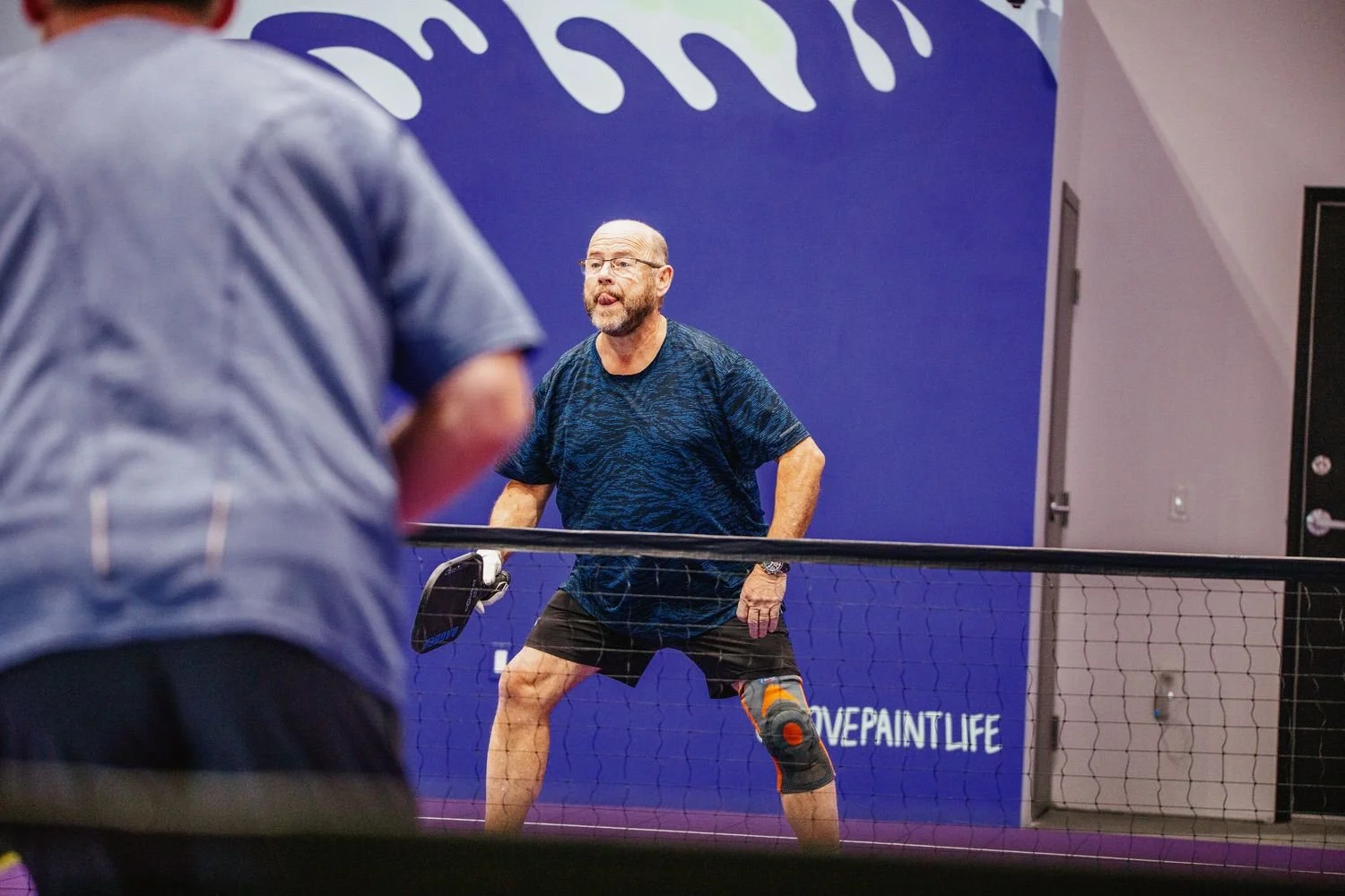 A player reaching for a shot on the indoor court at Pickleball Cove near Halifax