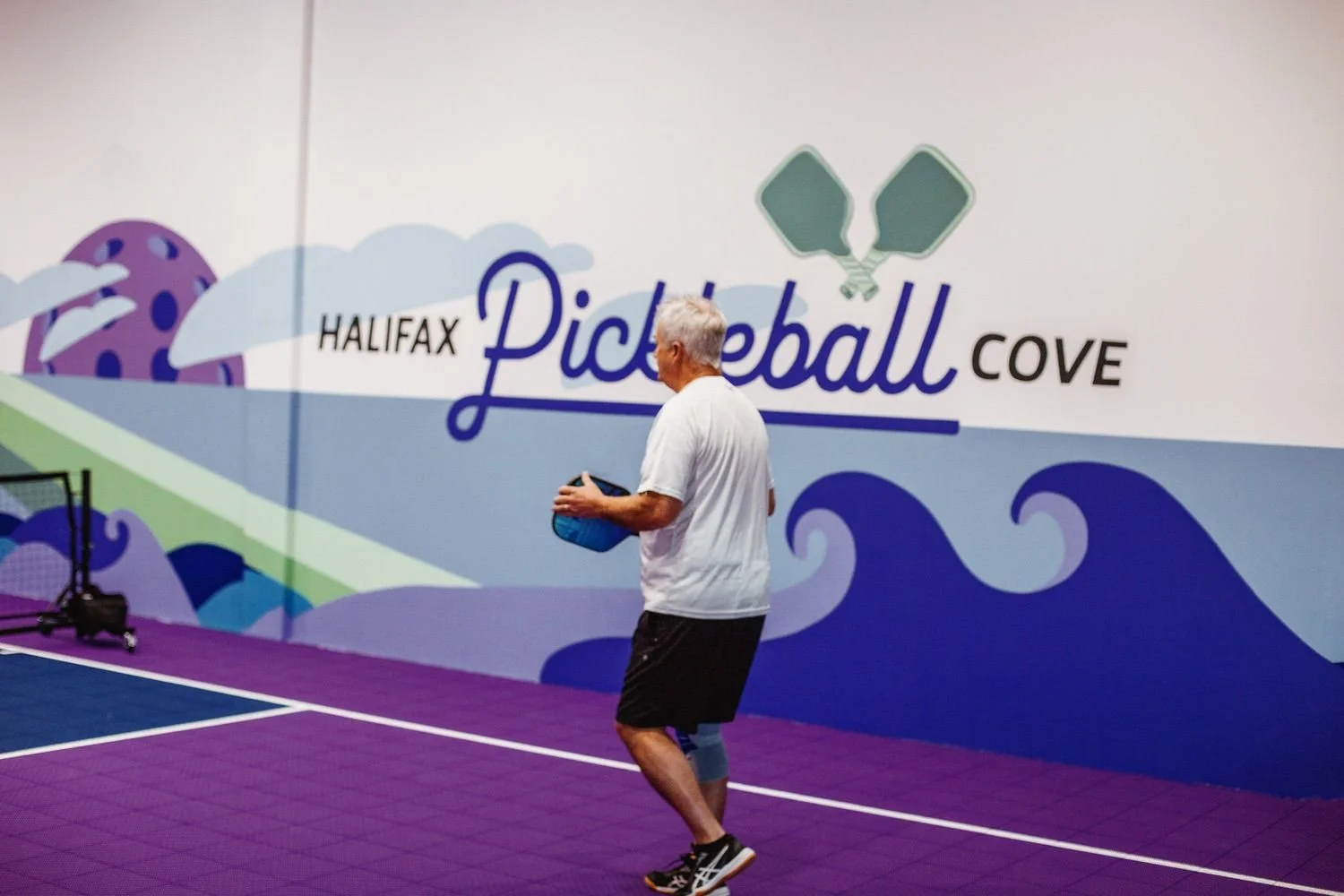 A player holding a pickleball paddle at Pickleball Cove